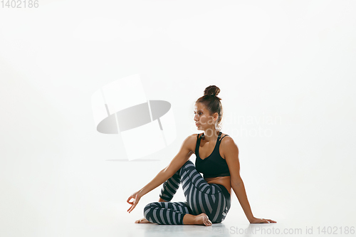 Image of Sporty young woman doing yoga practice isolated on white background