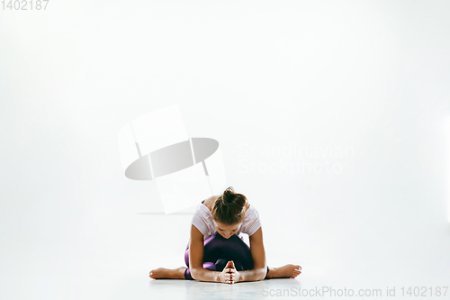 Image of Sporty young woman doing yoga practice isolated on white background