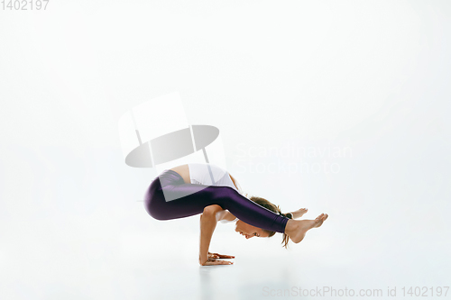 Image of Sporty young woman doing yoga practice isolated on white background