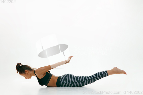 Image of Sporty young woman doing yoga practice isolated on white background