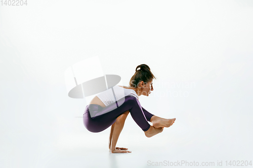 Image of Sporty young woman doing yoga practice isolated on white background