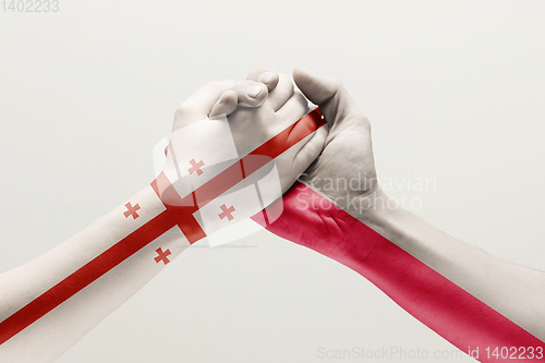 Image of Two hands. Flag of Georgia. Flag of Poland.