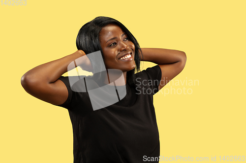 Image of Young african woman isolated on yellow studio background, facial expression