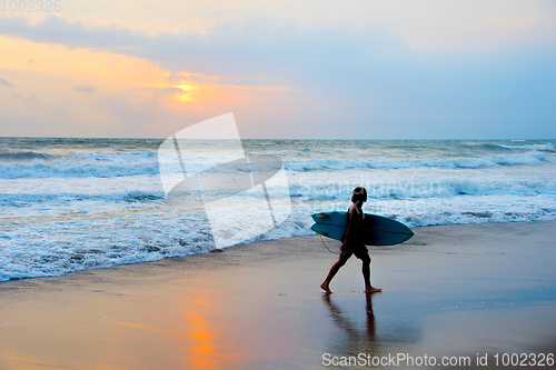 Image of Surfer at beach with surfboard