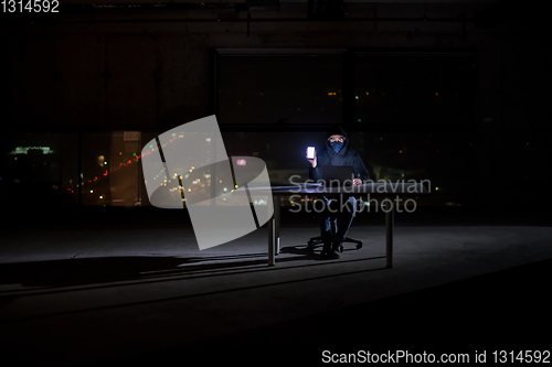 Image of hacker using laptop computer while working in dark office