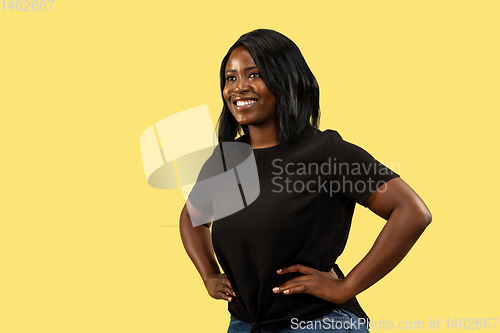 Image of Young african woman isolated on yellow studio background, facial expression