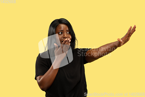 Image of Young african woman isolated on yellow studio background, facial expression