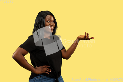 Image of Young african woman isolated on yellow studio background, facial expression