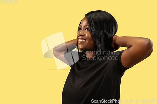 Image of Young african woman isolated on yellow studio background, facial expression