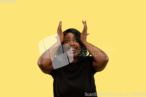 Image of Young african woman isolated on yellow studio background, facial expression