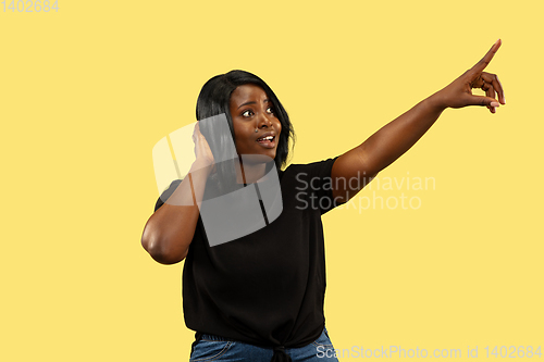 Image of Young african woman isolated on yellow studio background, facial expression