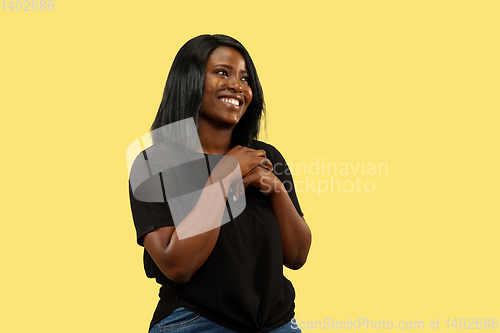 Image of Young african woman isolated on yellow studio background, facial expression