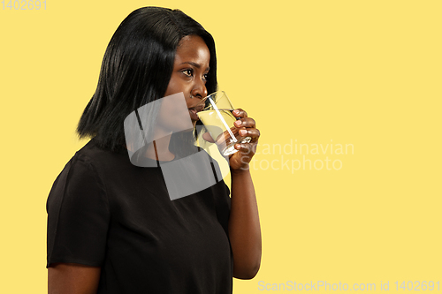 Image of Young african woman isolated on yellow studio background, facial expression