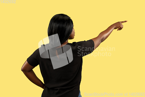 Image of Young african woman isolated on yellow studio background, facial expression