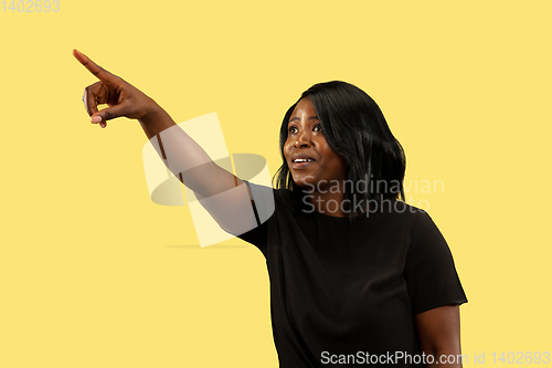 Image of Young african woman isolated on yellow studio background, facial expression