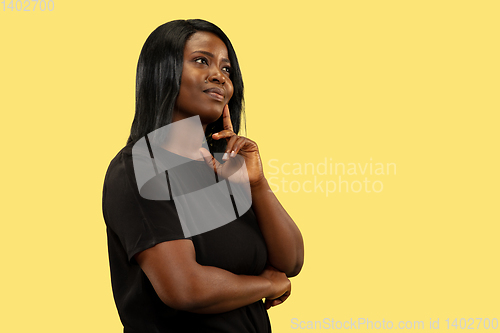 Image of Young african woman isolated on yellow studio background, facial expression