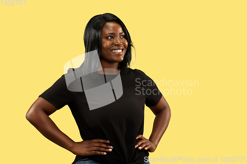 Image of Young african woman isolated on yellow studio background, facial expression