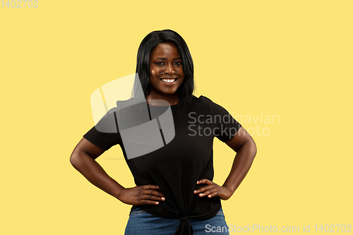 Image of Young african woman isolated on yellow studio background, facial expression