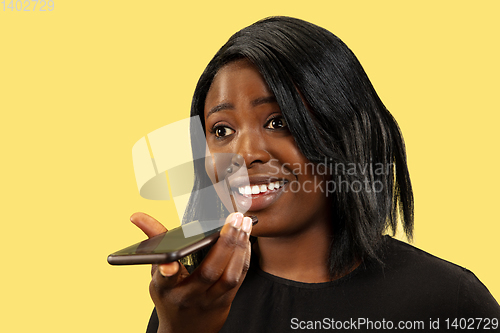 Image of Young african woman isolated on yellow studio background, facial expression