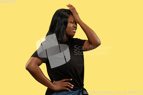 Image of Young african woman isolated on yellow studio background, facial expression