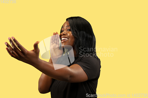 Image of Young african woman isolated on yellow studio background, facial expression