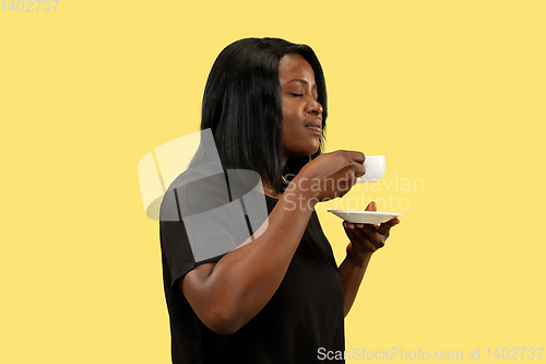 Image of Young african woman isolated on yellow studio background, facial expression