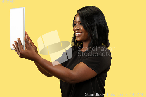 Image of Young african woman isolated on yellow studio background, facial expression