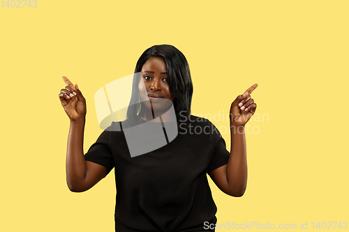 Image of Young african woman isolated on yellow studio background, facial expression