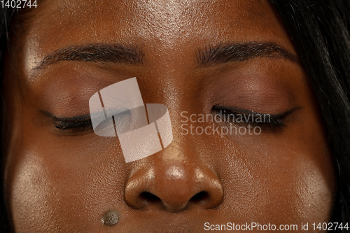 Image of Young african woman isolated on yellow studio background, facial expression