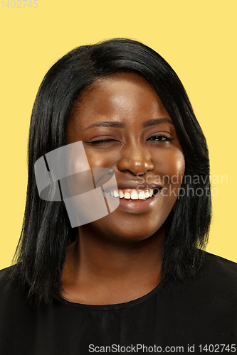 Image of Young african woman isolated on yellow studio background, facial expression