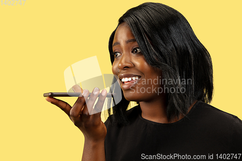 Image of Young african woman isolated on yellow studio background, facial expression