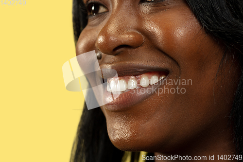 Image of Young african woman isolated on yellow studio background, facial expression