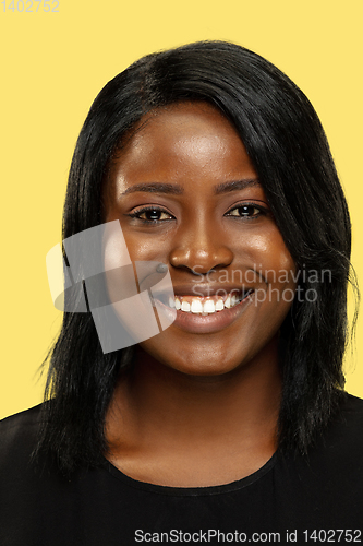 Image of Young african woman isolated on yellow studio background, facial expression