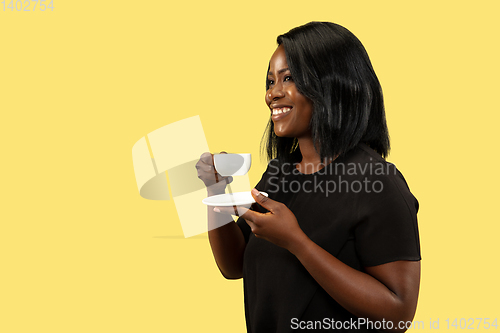 Image of Young african woman isolated on yellow studio background, facial expression