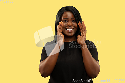 Image of Young african woman isolated on yellow studio background, facial expression