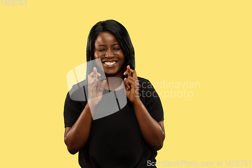 Image of Young african woman isolated on yellow studio background, facial expression