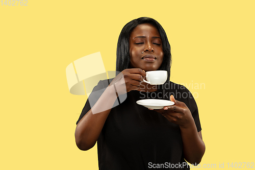 Image of Young african woman isolated on yellow studio background, facial expression