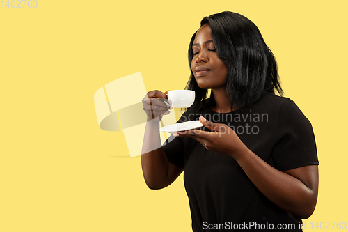 Image of Young african woman isolated on yellow studio background, facial expression