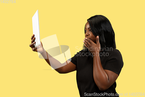 Image of Young african woman isolated on yellow studio background, facial expression