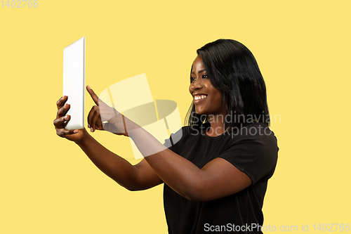 Image of Young african woman isolated on yellow studio background, facial expression