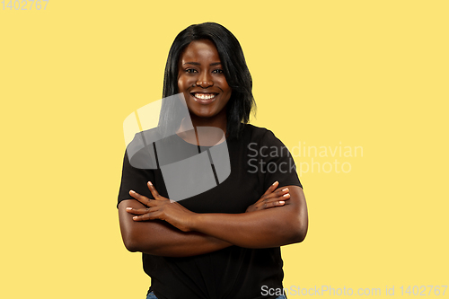 Image of Young african woman isolated on yellow studio background, facial expression