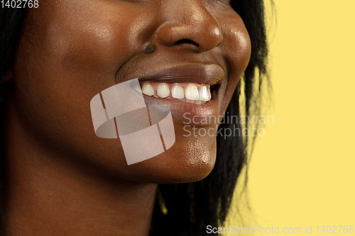 Image of Young african woman isolated on yellow studio background, facial expression