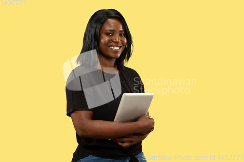 Image of Young african woman isolated on yellow studio background, facial expression