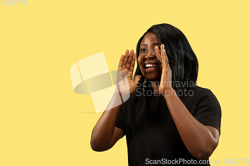 Image of Young african woman isolated on yellow studio background, facial expression