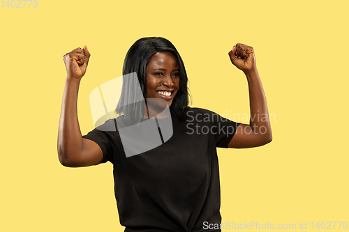 Image of Young african woman isolated on yellow studio background, facial expression