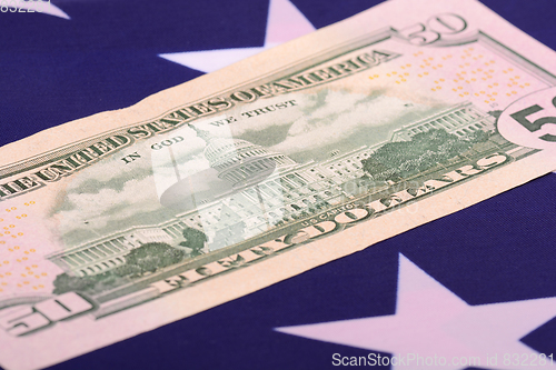 Image of fifty dollar bill in front of the American flag