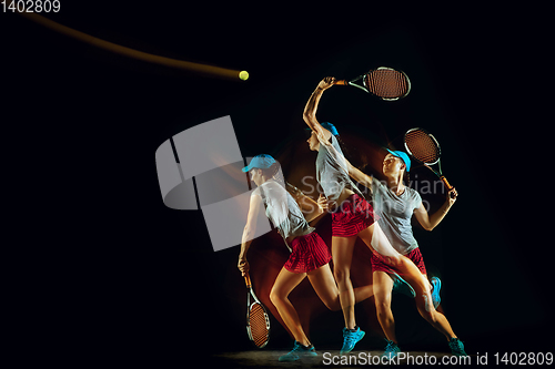 Image of One caucasian woman playing tennis on black background in mixed light