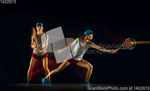 Image of One caucasian woman playing tennis on black background in mixed light