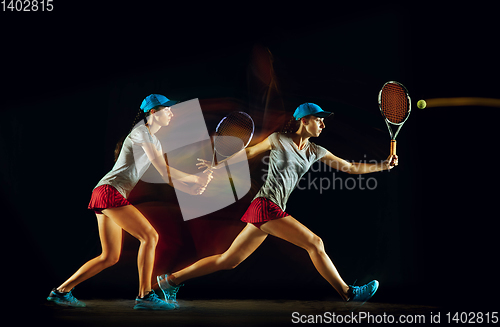 Image of One caucasian woman playing tennis on black background in mixed light