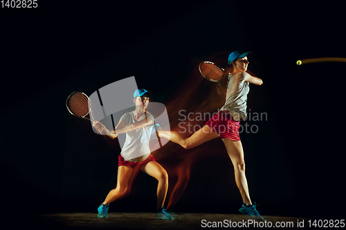 Image of One caucasian woman playing tennis on black background in mixed light